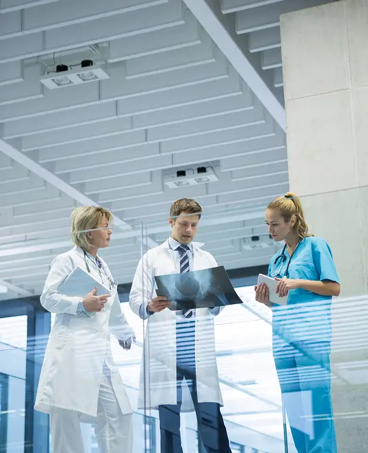medical-team-discussing-x-ray-report-corridor 1